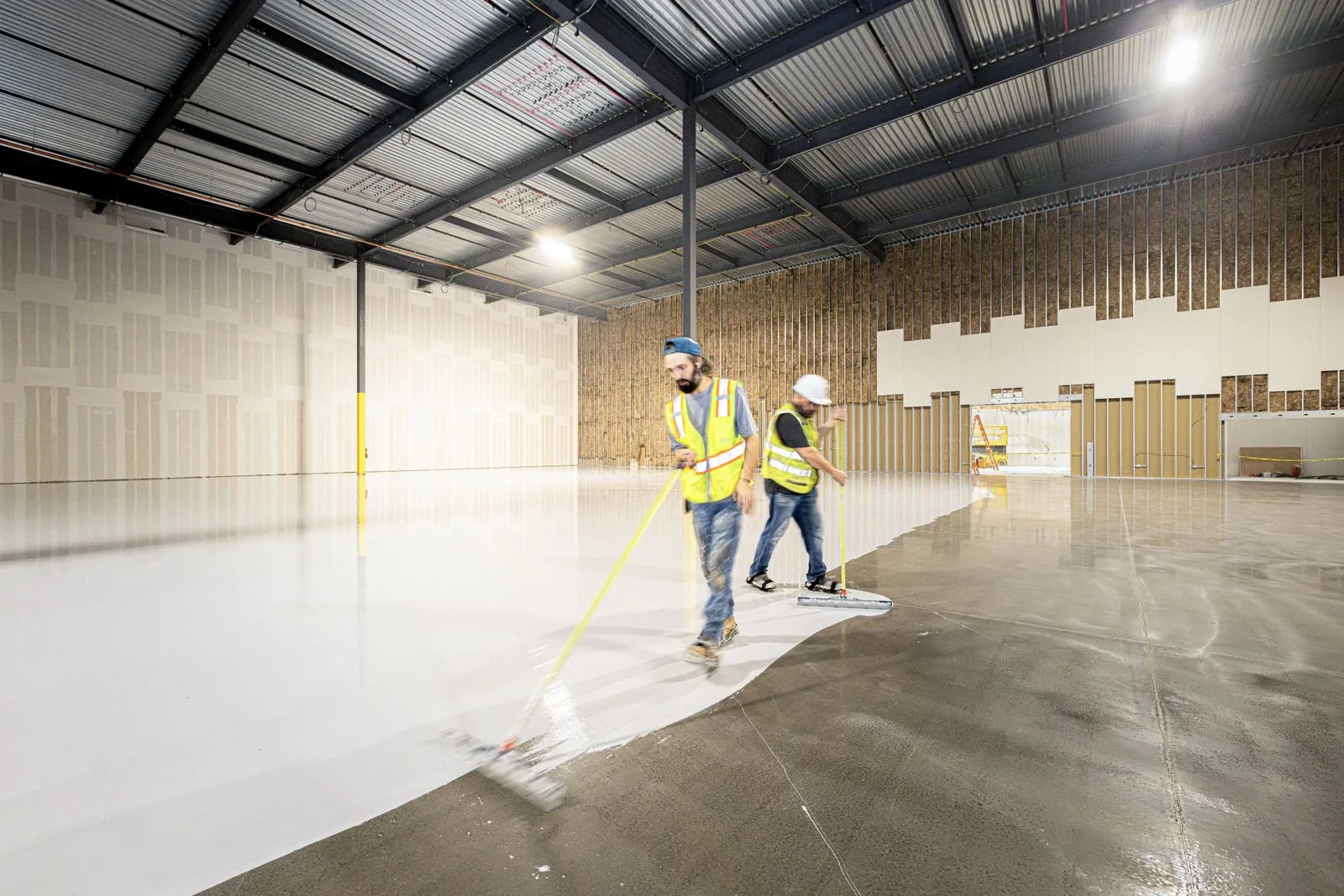 Workers applying a floor surface in a commercial building