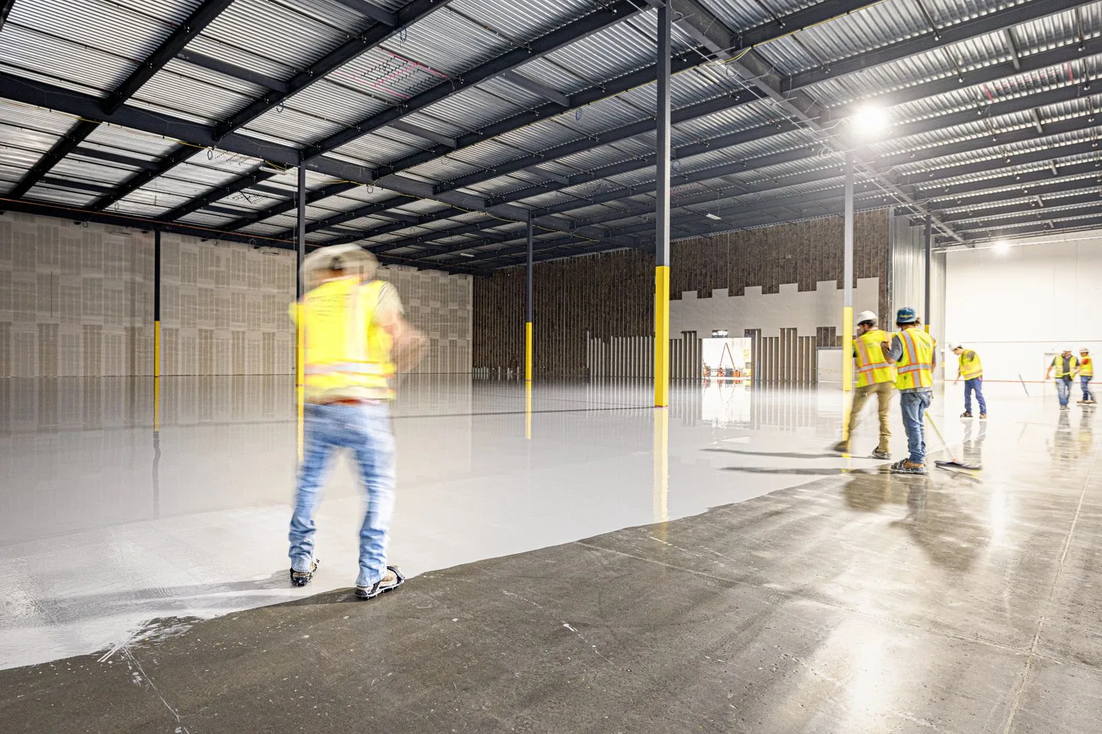 Flooring crew working across an industrial concrete surface